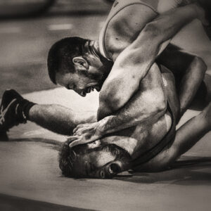 Picture of two men wrestling, with one being pinned to the mat. Source Pixabay.com.