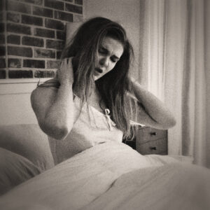 Picture of a woman waking up in bed. Rough hair, yawn, and stretching out. Source Pixabay.com.