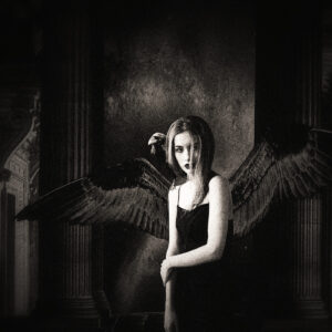 Picture of a woman in a black dress with black unfurled wings to match. Source Pixabay.com.