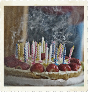 Picture of a birthday cake with the candles blown out. Smoke is billowing over the cake. Image by M W from Pixabay.