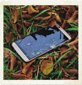 Picture of a damage phone on the ground amongst leaves. Image by Volker Glätsch from Pixabay.