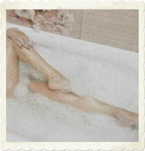 Picture of a pair of legs in a bath heavy with bubbles. Image by Victoria Art Music from Pixabay.