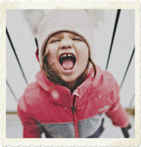 Picture of a girl in tuque and winter coat, looking up, eyes closed, mouth wide open, looking as though she is having a tantrum. Image by Stephen Andrews on Pexels.