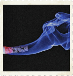 Picture of a cigarette smoke with blue smoke wafting away. Image by Ralf Kunze from Pixabay.