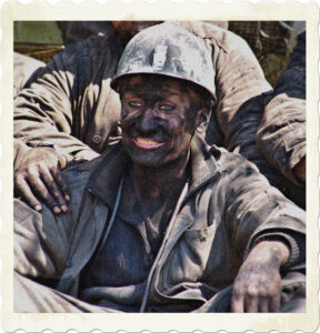 Picture of a miner, caked in dirt and smiling. Teeth, lips, and eyes only part not coated. Image by Анатолий Стафичук from Pixabay.