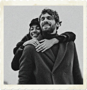 Picture of a woman hugging a man from behind, seemingly happy doing so. Image by Cottonbro on Pexels.