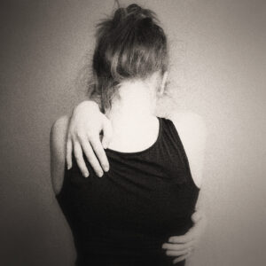 Image of a woman facing away from us hugging herself. Image by Anemone123 from Pixabay.com.