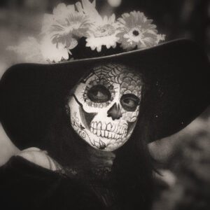 Image of a woman in black with skull makeup. Source Pixabay.com.