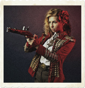 Picture of a woman in a red ornate uniform, pointing a flintlock pistol. Image by Victoria Model from Pixabay.
