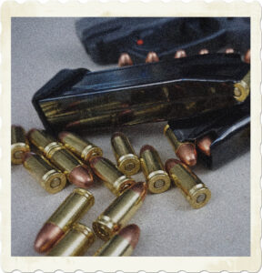 Picture of a firearm, magazines, and stray cartriges. Image by MikeGunner from Pixabay.