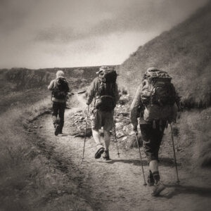 Picture of three hikers in colourful grab following each other down a trail. Source Pixabay.com.