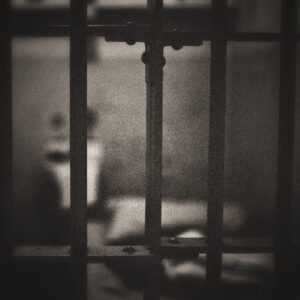 Picture of a prison cell, with the bars in focus. Source Pixabay.com.