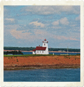 Picture of a lighthouse with a house attached sitting on a peninsula. The iconic red shores of the region are visible.