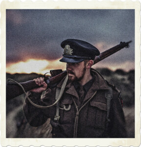 Picture of an officer in the marines as judged by the cap badge and single bar with an executive curl. Dressed for combat in the Great War with a rifle laying against his shoulder and finger on the trigger. Image by Alex Andrews from Pexels.