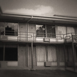 Picture of a motel from the outside, two levels with stairs. Source Pixabay.com.