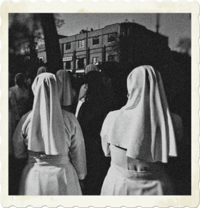 Picture overlooking a public space with several nuns in view. In the background a old building that appears to contain stores. Image by Jair Hernandez from Pexels.