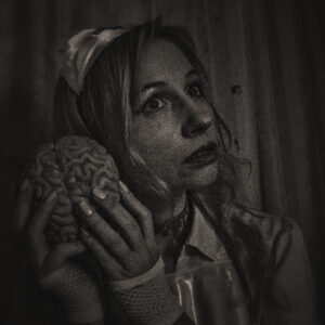 Picture of a woman dressed as a nurse, holding a brain. Source Pixabay.com.