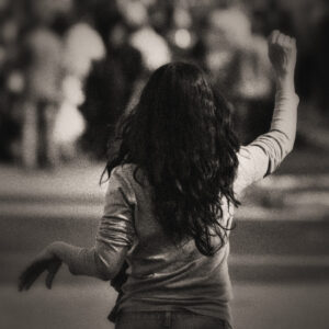 Picture of a long haired woman from the pack, appears to be waiving to someone. Source Pixabay.com.