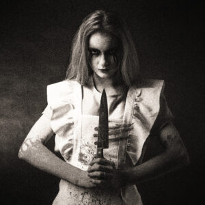 Picture of a woman holding a knife with both hands. Knife, arms and white clothes are bloodied, mascara streaked. Source Pixabay.com.