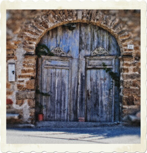 Picture of an imposing brick and mortal wall centred on a heavy wooden door, with smaller doors built within. Image by Pixabay from Pexels.