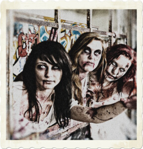 Picture of three female zombies, with white eyes, blood smeared faces and skin. White dresses are marred with blood as well. Image by SvenKirsch from Pixabay.