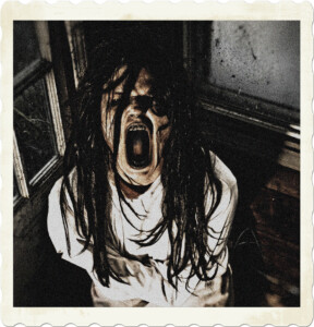 Picture of someone in a straight hacked with long dirty hair, distorted features, mouth opened well beyond where it should screaming out into the dark.