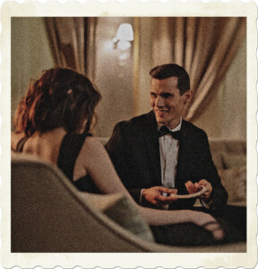 Picture of a man and woman wearing formal atire in a room that appears to be opulent. Man is holding some sort of necklace, presumably to give it to the brunette. Image by Cottonbro on Pexles.