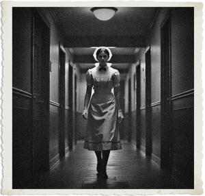 A dramatic black-and-white vintage-style photograph with torn paper edges, depicting a stern-faced nurse in a traditional white uniform, cap, and apron walking directly toward the viewer down the center of a long, shadowy institutional hallway. The dimly lit corridor features dark doors, wainscoting, and overhead lighting that creates deep contrast and a sense of unease.