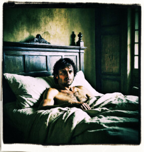Picture of a black haired man with no clothes lying in bed. Haggard, runs a hand though his hair. Located a simple bedroom. Clothes and scene appropriate to the 16th Century France.