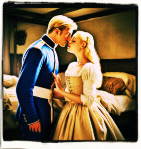 Blonde with blue eyes, wearing a slip, kissing a man in uniform. Standing in a simple bedroom. Clothes and scene appropriate to the 16th Century France.