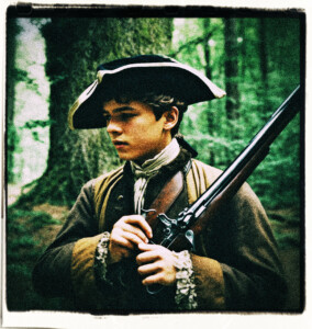 Teenage boy loading a flintlock pistol in the woods. Clothes and background appropriate for 16th century France.