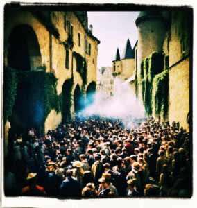Crowd of 50 dispersing. Located near the castle gates. Background and scene appropriate to 16th century France.