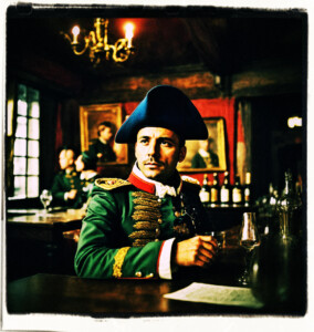 Picture of an French army officer in a tavern. Man looks embarassed. Clothes and background appropriate for 16th century France tavern.