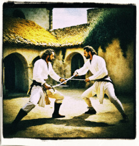 Two men wearing in white shirts, pants, and leather boots, facing off each other with swords.